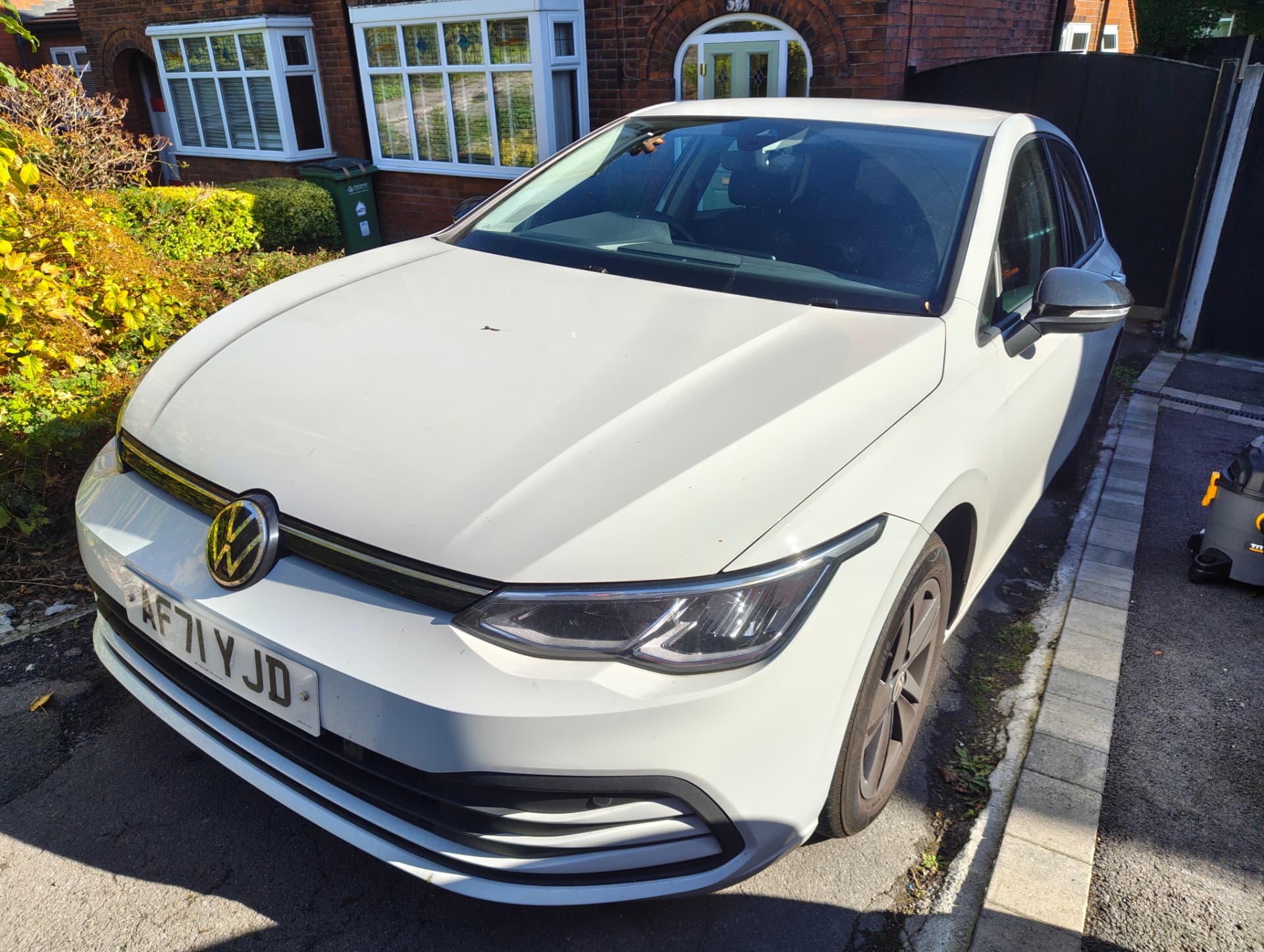 White Volkswagen Golf front with brake-dust coated wheels and debris on the bonnet before detailing