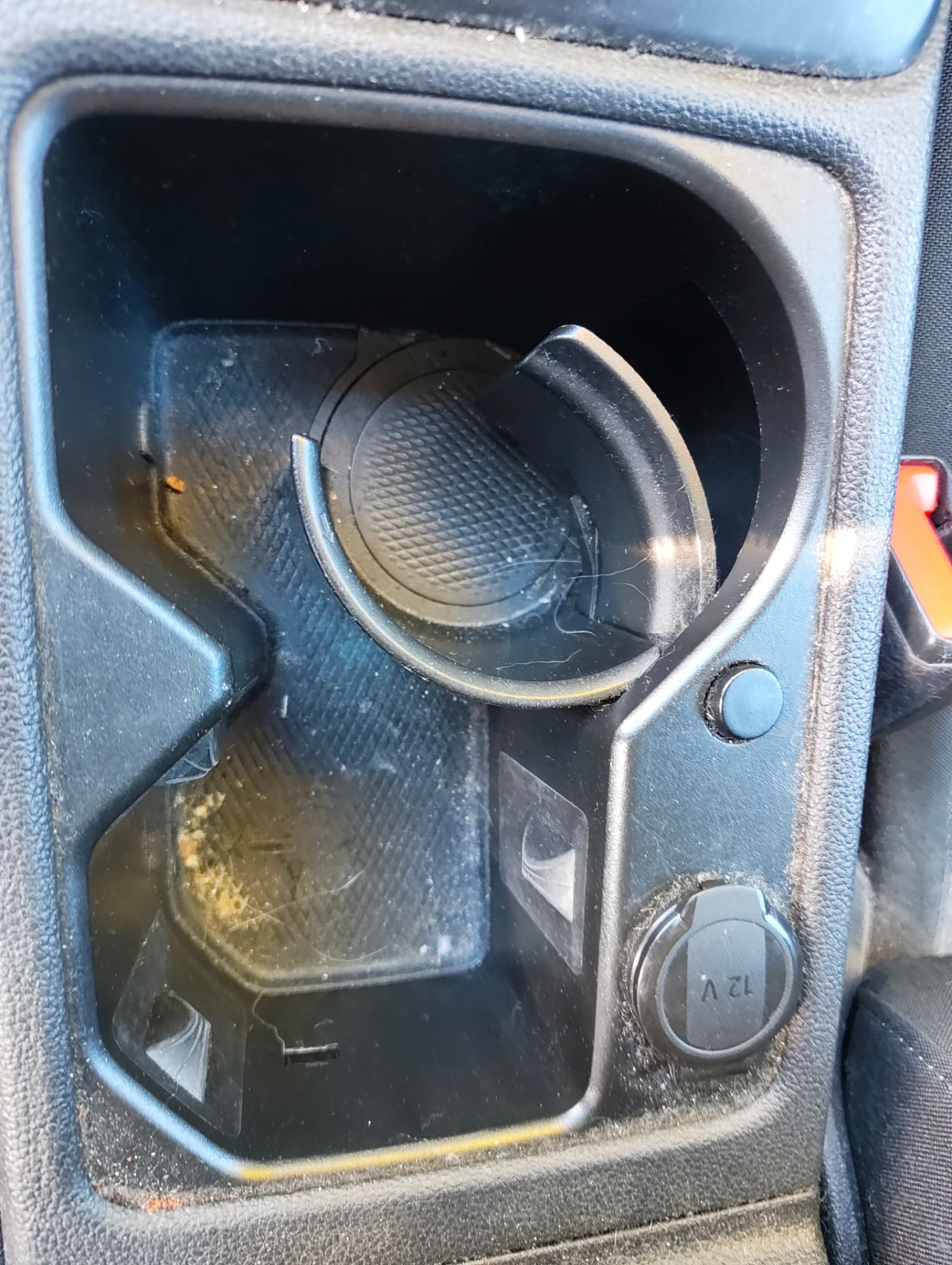 Golf centre console cup holders with crumbs and sticky residue before cleaning