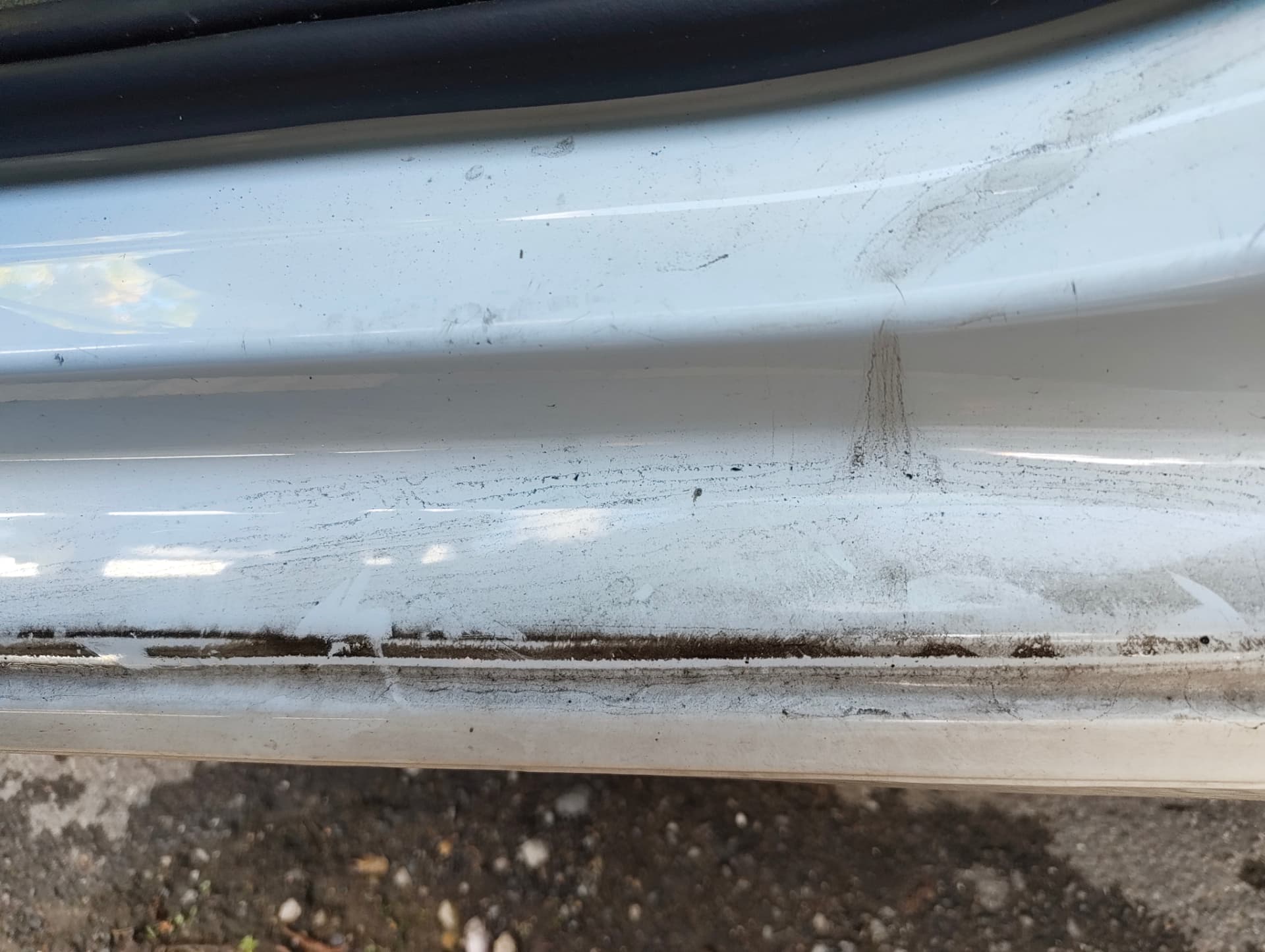 Golf door sill with built-up grease and road grime before cleaning